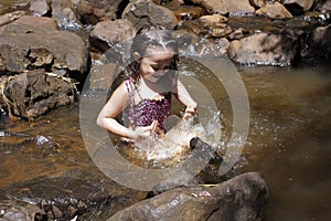 Little girl playing at the waterfall in Brotas photo